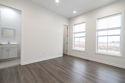 an empty living room with white walls and wood flooring