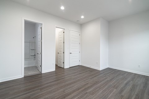 a living room with white walls and a door to a bathroom