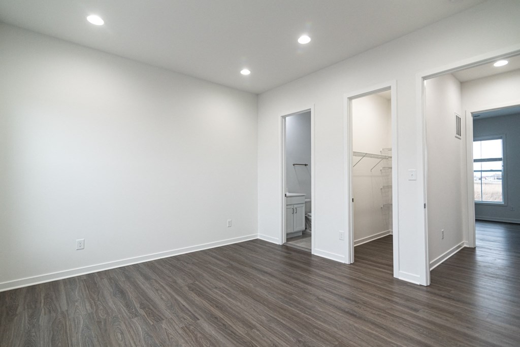 an empty living room with white walls and wood flooring