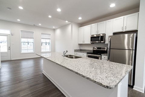 a kitchen with a granite counter top and a stainless steel refrigerator