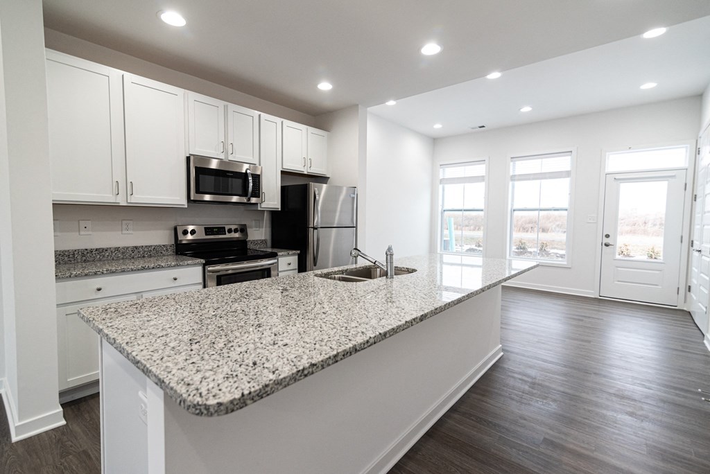 a kitchen with granite counter tops and white cabinets