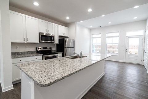 a kitchen with granite counter tops and white cabinets