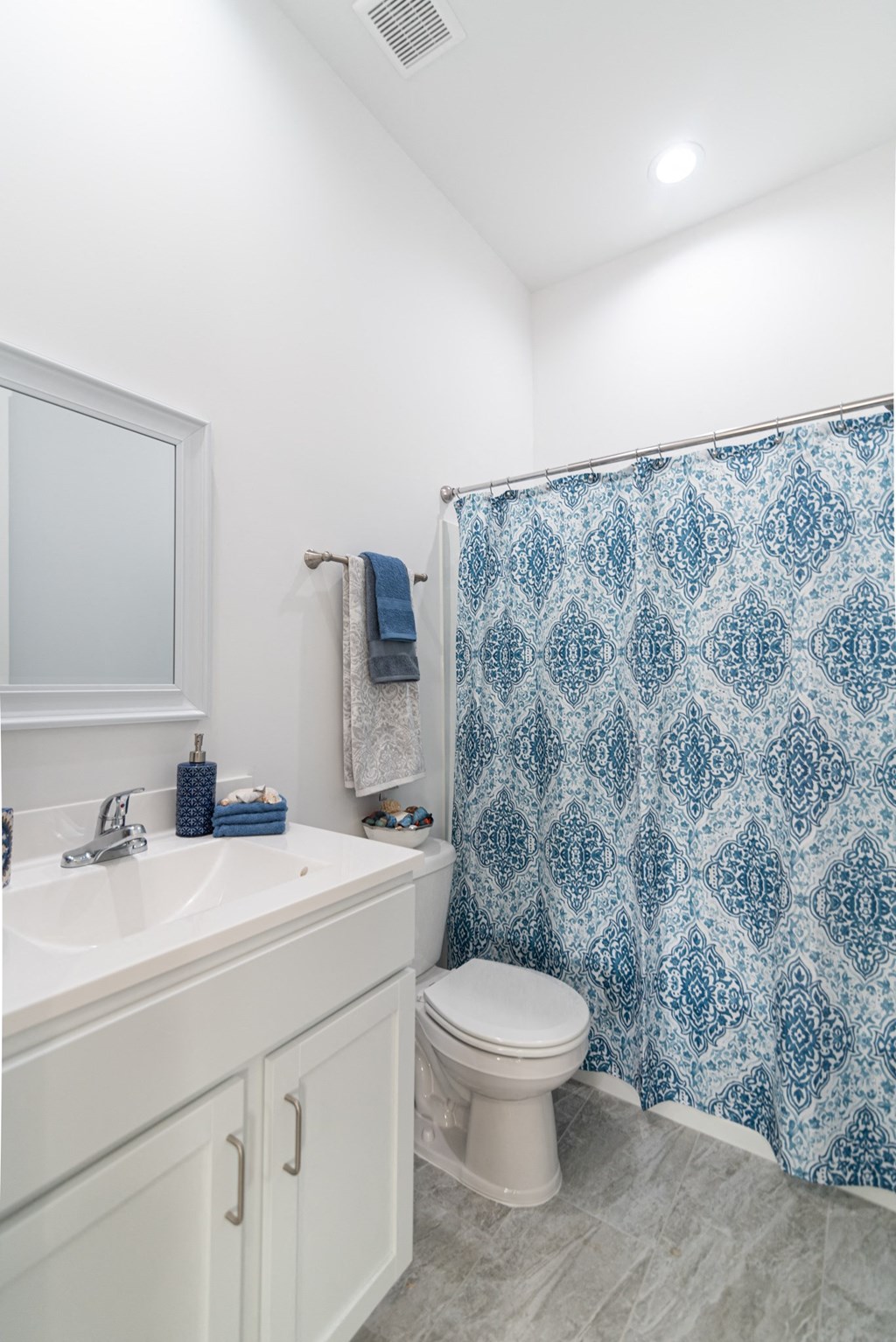 a bathroom with a blue and white shower curtain and a toilet
