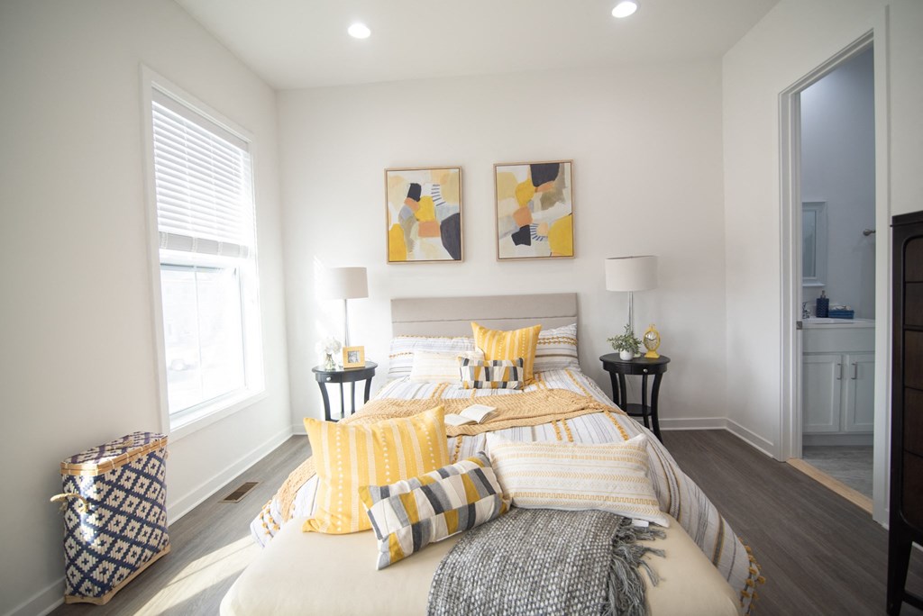a bedroom with a large bed and yellow pillows