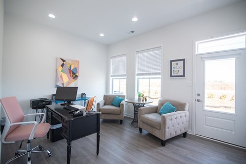 a home office with a desk and chairs and a computer