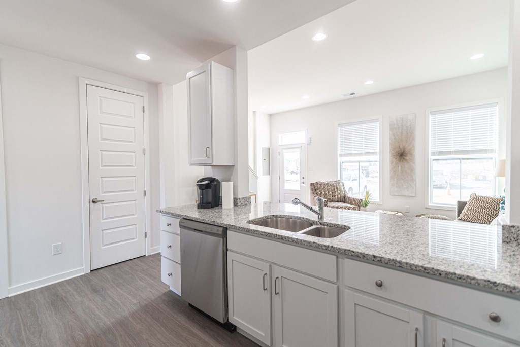 a kitchen with white cabinets and a sink and a counter top