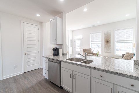 a kitchen with white cabinets and a sink and a counter top