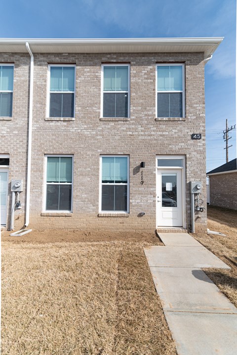 a brick building with a white door and a sidewalk