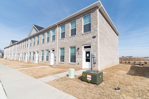 a brick building with a green utility box in front of it