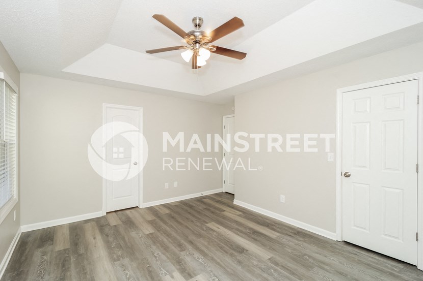 an empty room with a ceiling fan and a door