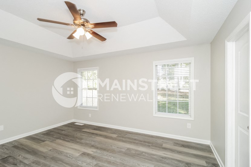 an empty room with a ceiling fan and a window