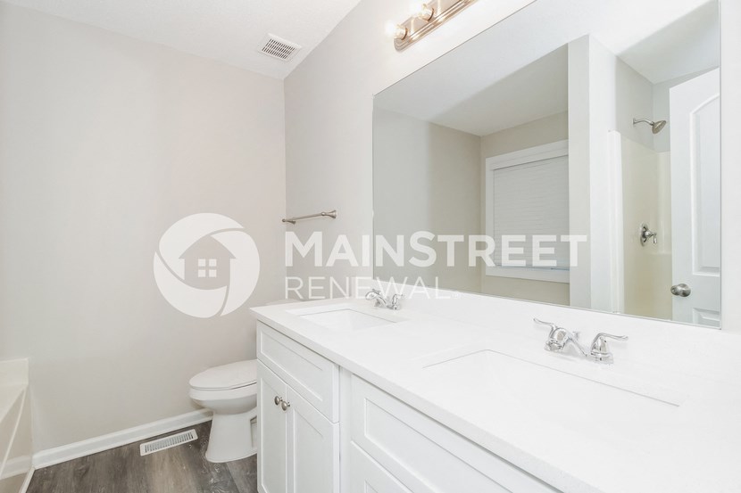 a white bathroom with a white sink and a toilet