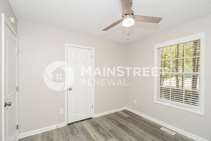 a bedroom with a white door and a window