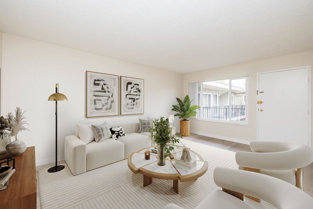 A living room with a white couch, a coffee table, and a lamp.