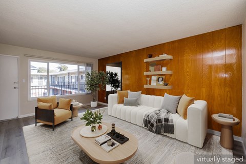 A living room with a white couch and a wooden coffee table.