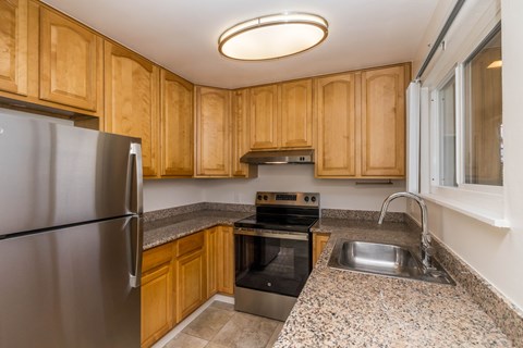 A kitchen with wooden cabinets and a granite countertop.