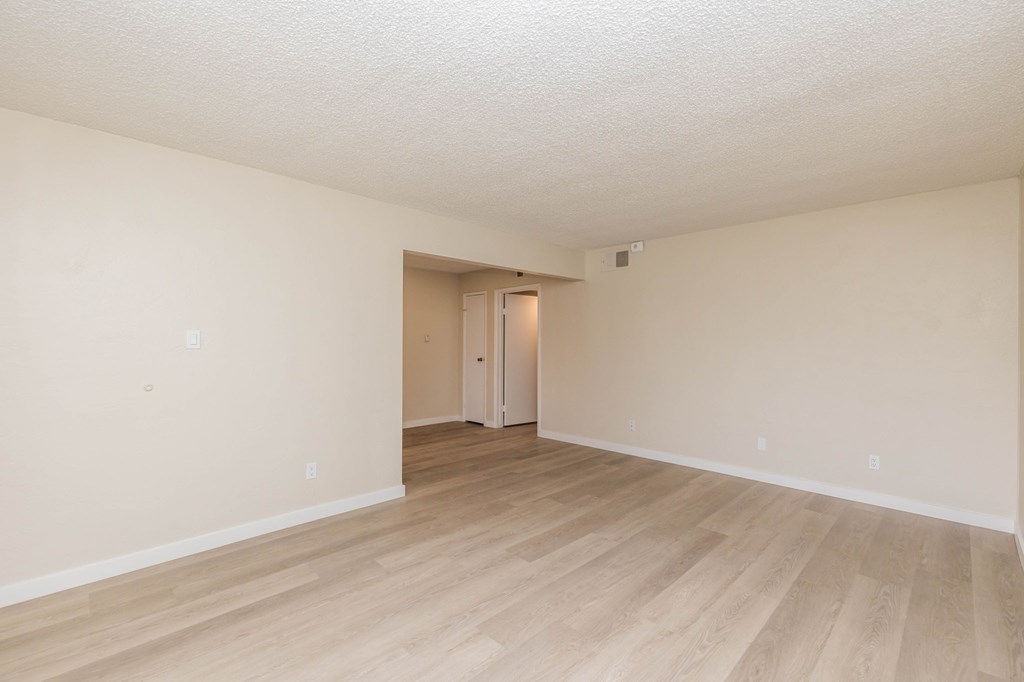 A room with light wood flooring and white walls.