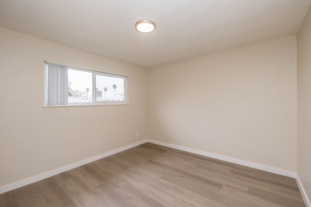 A room with a window and wooden flooring.