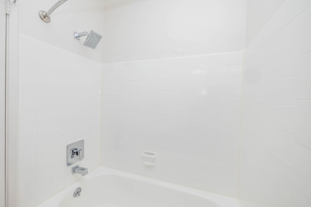 A white bathroom with a shower and tub.