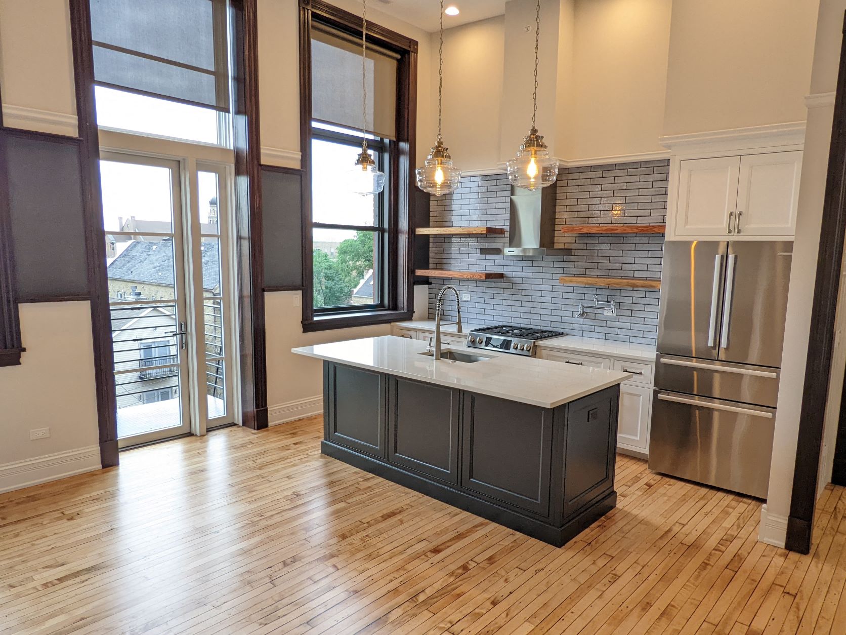 a kitchen with a center island and a stainless steel refrigerator