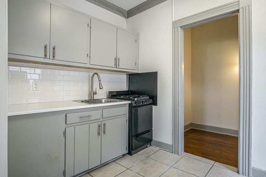 a kitchen with white cabinets and a stove and a sink