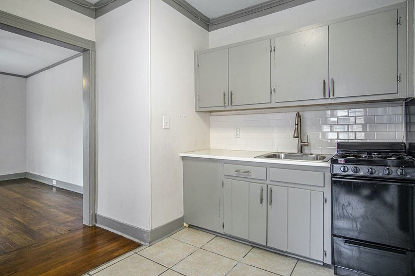 a kitchen with white cabinets and a stove and a sink