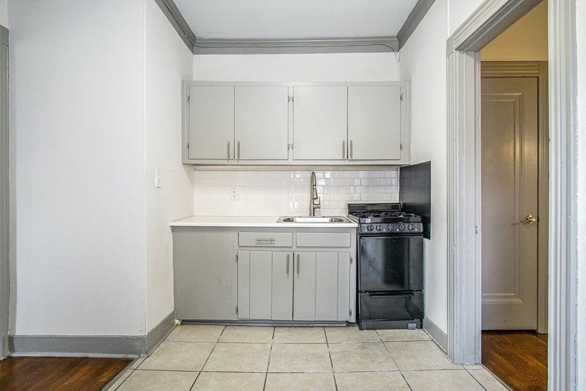 a kitchen with white cabinets and a stove and a sink