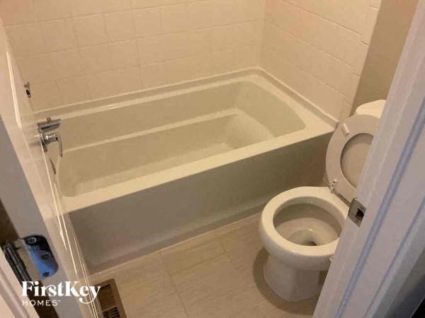 a bathroom with a toilet and a bath tub