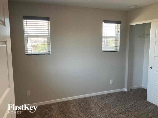 an empty room with two windows and a door