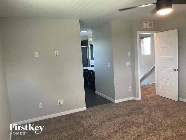 an empty living room with a door to a bathroom