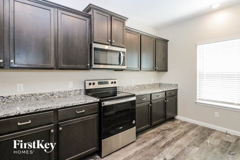 a kitchen with dark wood cabinets and granite counter tops