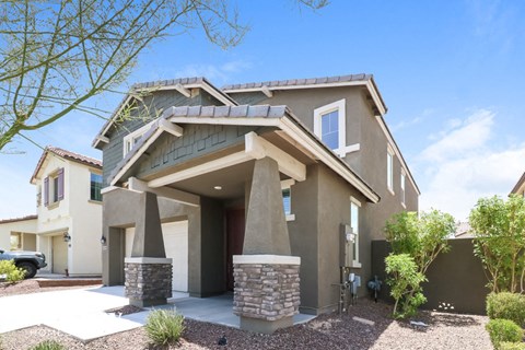 A modern house with a stone pillar in front.
