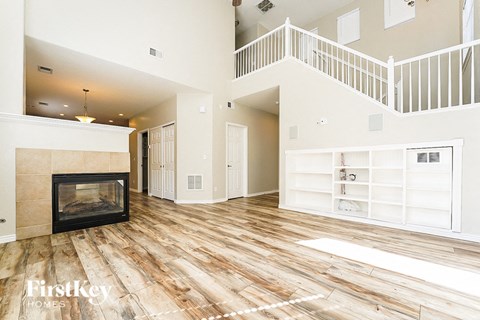 A spacious living room with a fireplace and wooden flooring.