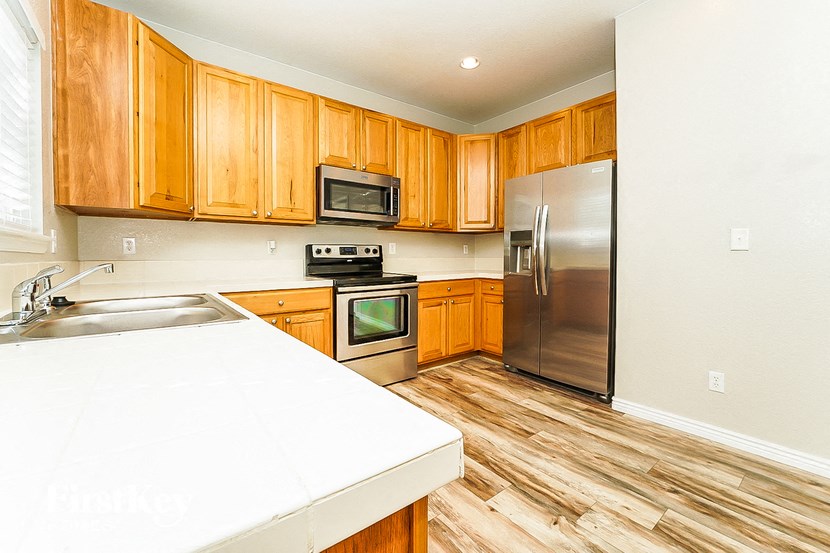 A kitchen with wooden cabinets and a stainless steel refrigerator.