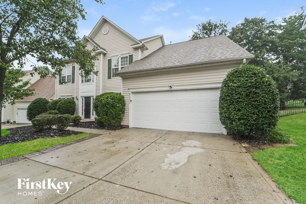 a white house with a driveway and a garage door