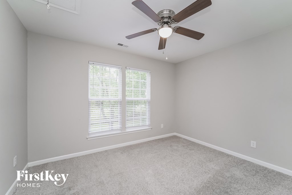 a bedroom with a ceiling fan and a window