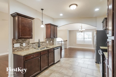 A kitchen with brown cabinets and a granite countertop.