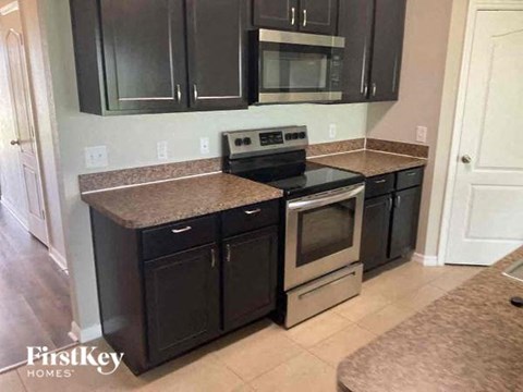 a kitchen with black cabinets and stainless steel appliances