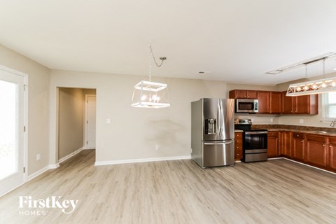 a kitchen and living room with wood flooring and a stainless steel refrigerator
