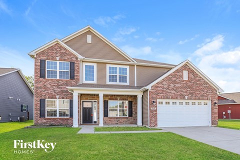 A brick house with a garage and a sign that says FirstKey Homes.