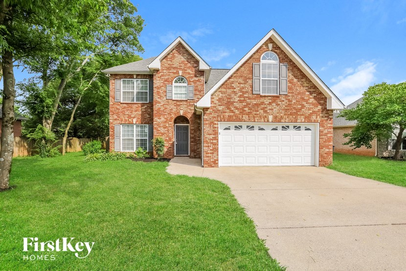 a brick house with a white garage door and a lawn