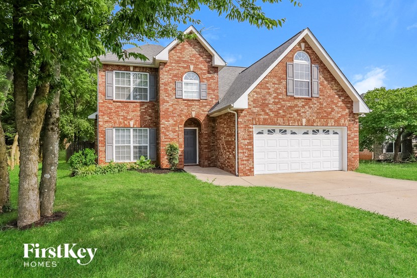 a brick house with a white garage door and a lawn