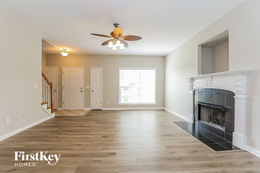 a living room with a fireplace and a ceiling fan