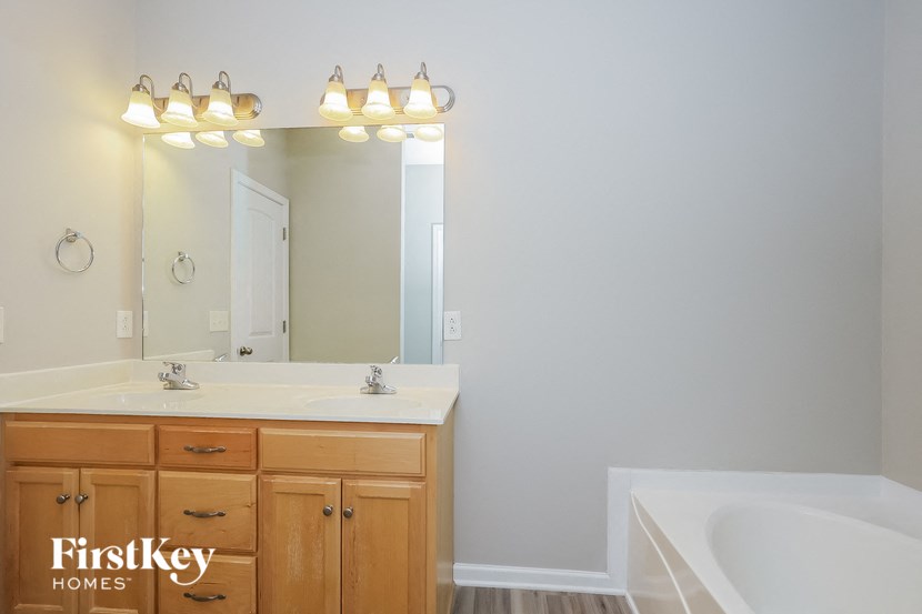 a bathroom with two sinks and a mirror and a tub