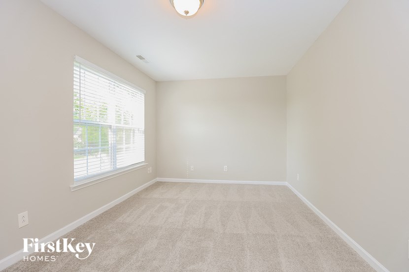 a spacious living room with carpet and a large window