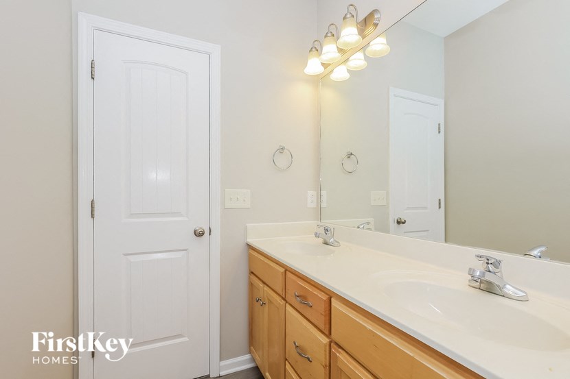 a bathroom with a sink and a mirror and a door