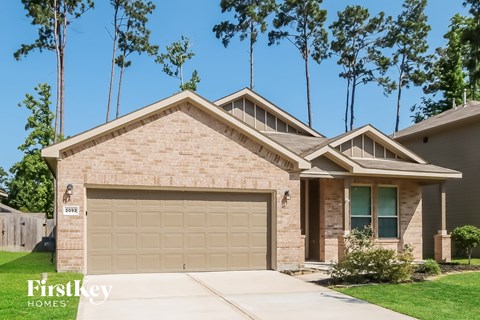 A house with a garage and a driveway in front of it.