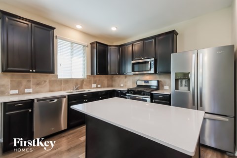 A modern kitchen with stainless steel appliances and black cabinets.