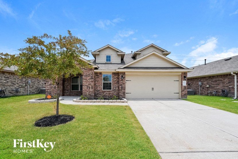 a house with a driveway and a tree in the yard