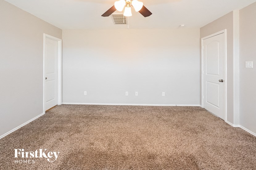 a bedroom with a carpeted floor and a ceiling fan